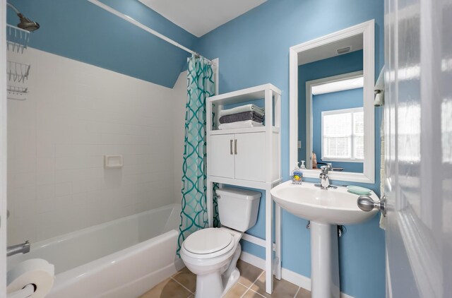 bathroom featuring tile patterned flooring, shower / bath combination with curtain, and toilet