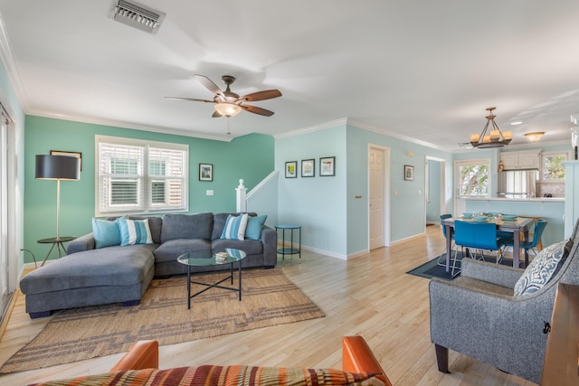 living room featuring crown molding, ceiling fan, and light wood-type flooring