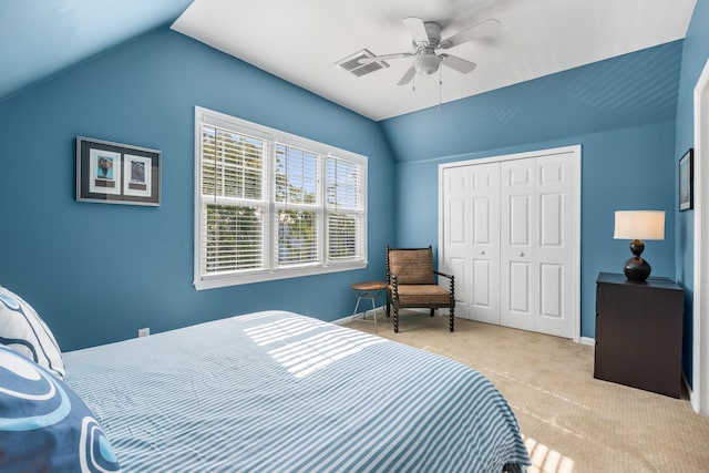 bedroom with lofted ceiling, light carpet, a closet, and ceiling fan