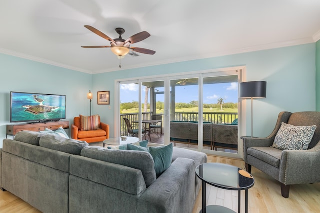 living room with crown molding, ceiling fan, and light wood-type flooring