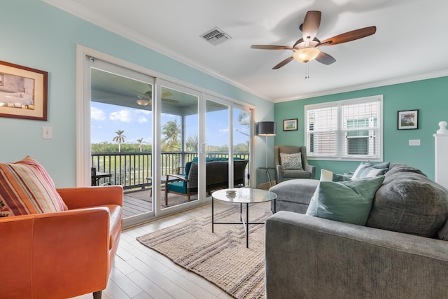 living room featuring ornamental molding, plenty of natural light, and light hardwood / wood-style floors