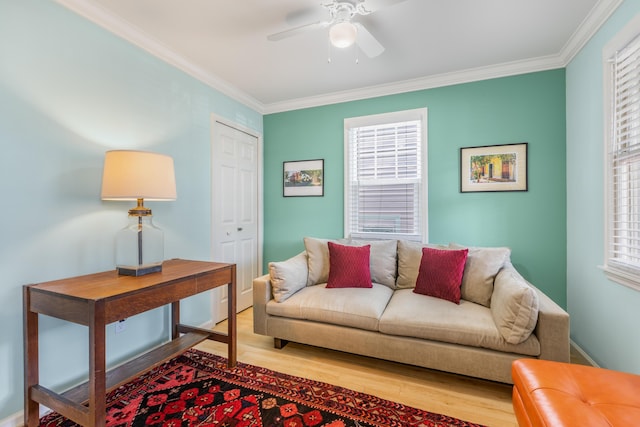 living room featuring hardwood / wood-style flooring, ornamental molding, and a healthy amount of sunlight