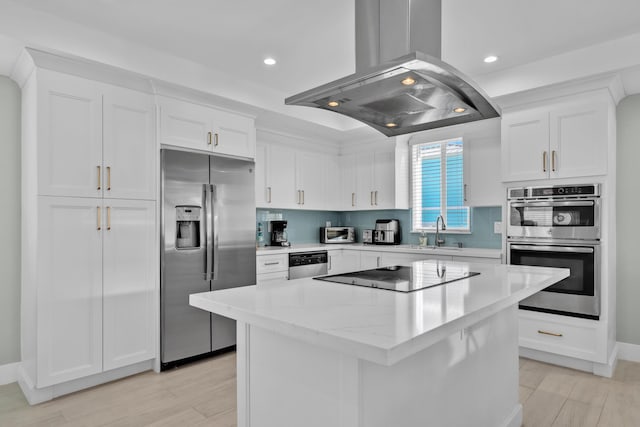 kitchen with sink, appliances with stainless steel finishes, a center island, island range hood, and white cabinets