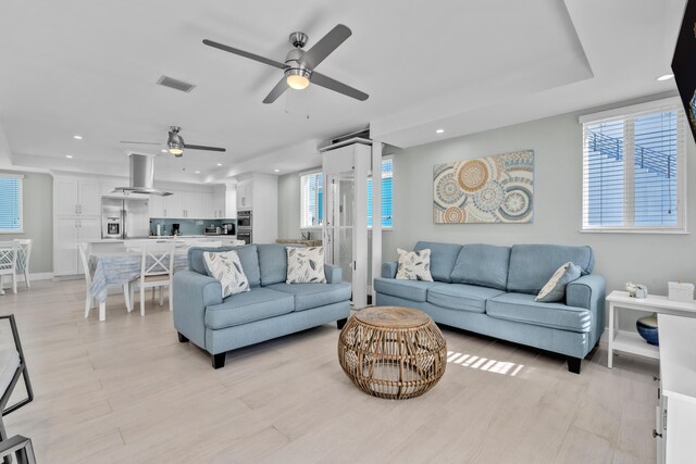 living room with ceiling fan, light hardwood / wood-style flooring, and a healthy amount of sunlight