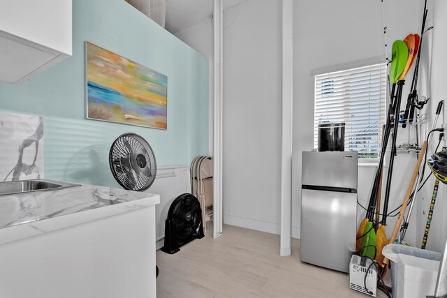 laundry area with light hardwood / wood-style floors