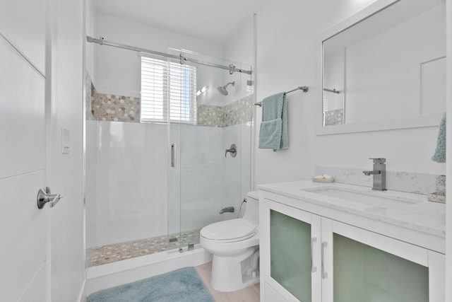 bathroom featuring vanity, toilet, and walk in shower