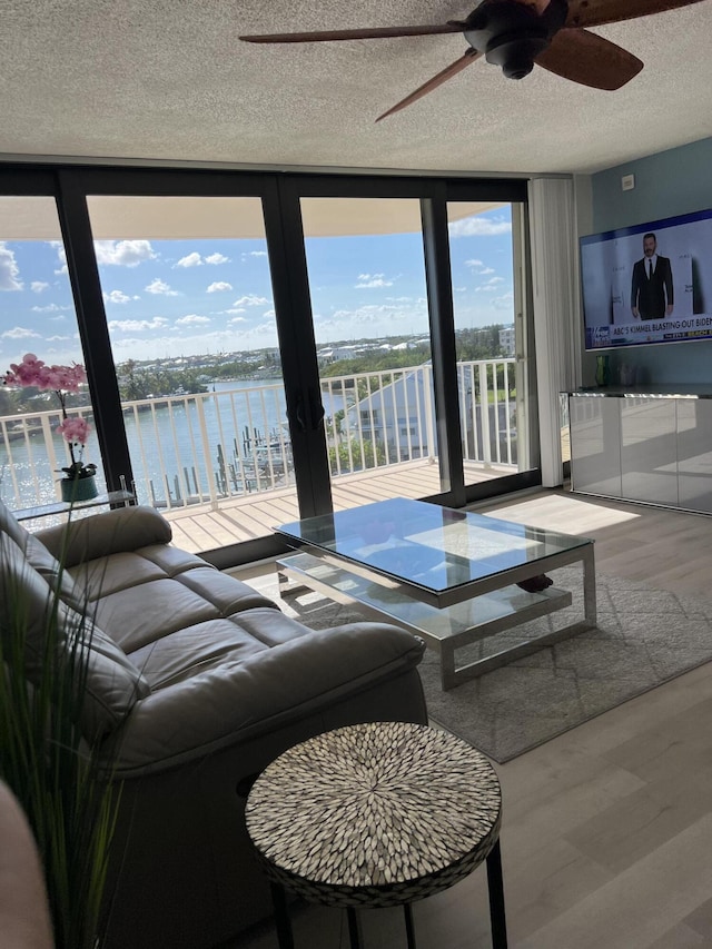 2000 Coco Plum Dr Unit 605, Marathon, FL 33050 - living room with plenty of natural light, a textured ceiling, a ceiling fan, wood finished floors, and expansive windows