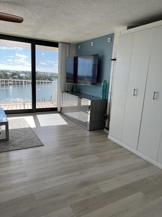 2000 Coco Plum Dr Unit 605, Marathon, FL 33050 - unfurnished living room with expansive windows, wood finished floors, and a textured ceiling