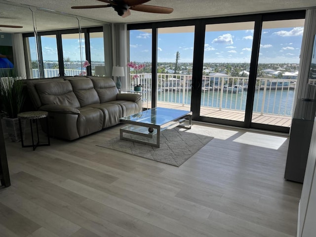 2000 Coco Plum Dr Unit 605, Marathon, FL 33050 - living area with ceiling fan, a water view, floor to ceiling windows, healthy amount of natural light, and wood finished floors
