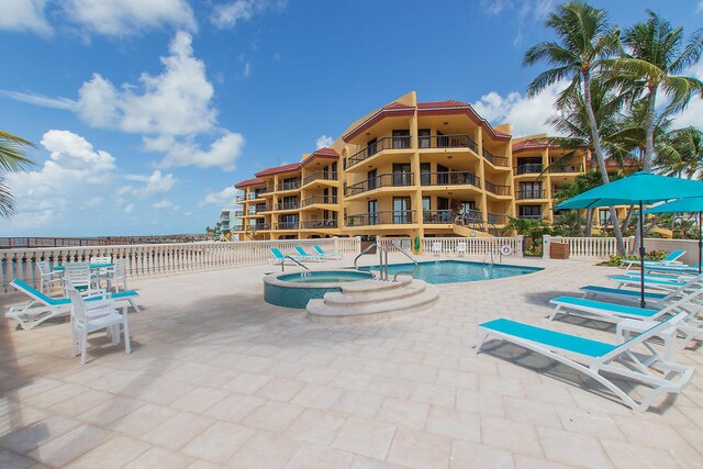 view of swimming pool featuring a patio area and a hot tub