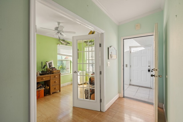 doorway with light wood-style flooring, baseboards, and crown molding