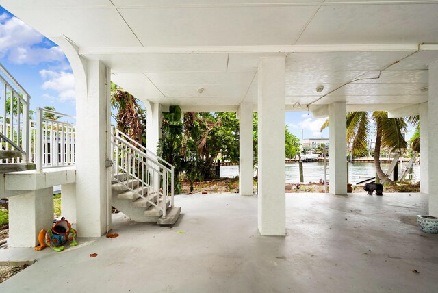 view of patio with stairs and a water view