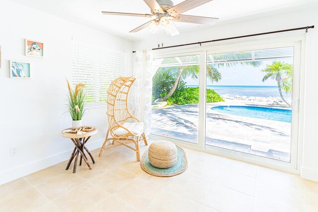 sitting room with tile patterned flooring and ceiling fan