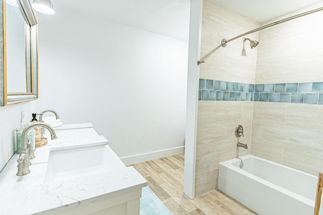 bathroom featuring vanity, hardwood / wood-style floors, and tiled shower / bath