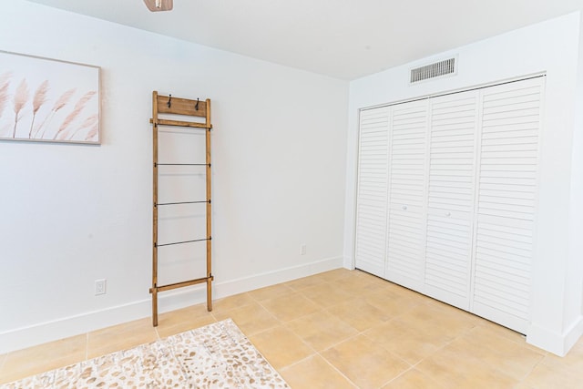 unfurnished bedroom with tile patterned floors and a closet