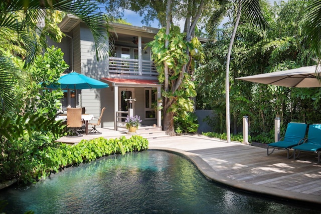 rear view of house with a pool side deck and ceiling fan