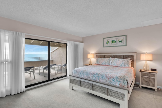 bedroom featuring carpet floors, access to exterior, and a textured ceiling