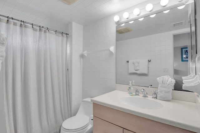 full bath featuring visible vents, toilet, a shower with curtain, vanity, and tile walls