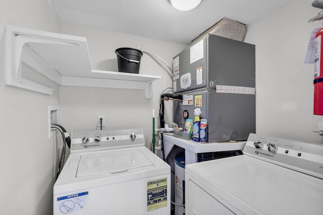 clothes washing area featuring heating unit, laundry area, and washing machine and clothes dryer