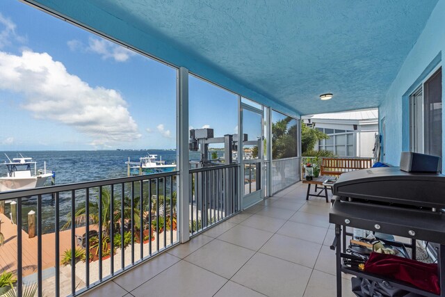 balcony featuring a water view and a grill