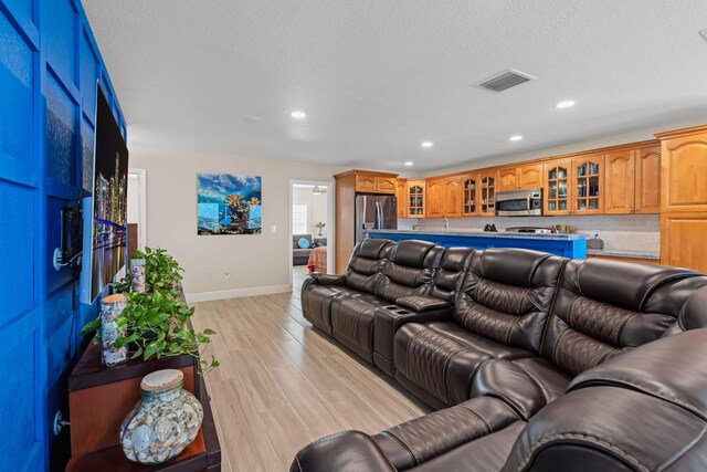 living room with light hardwood / wood-style flooring and a textured ceiling