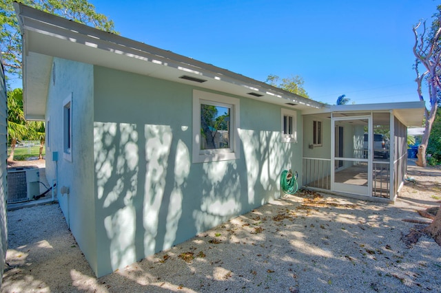 view of side of property with a sunroom and central AC unit