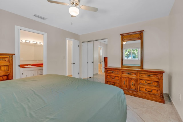 bedroom with connected bathroom, sink, light tile patterned floors, ceiling fan, and a closet