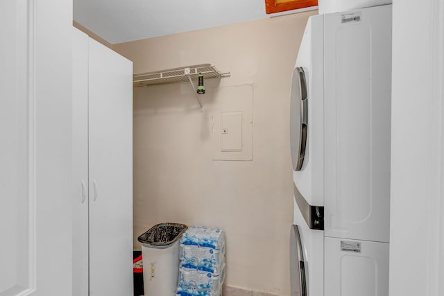 washroom with stacked washer / dryer and cabinets