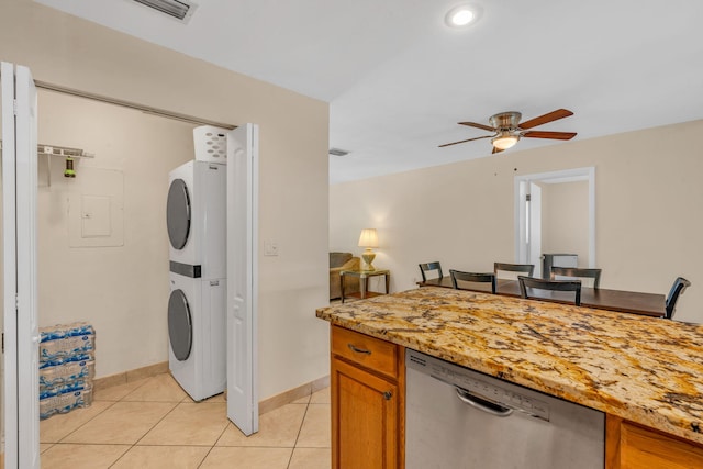 laundry area with light tile patterned flooring, stacked washer and clothes dryer, and ceiling fan