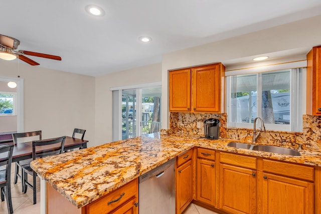 kitchen with light tile patterned flooring, sink, stainless steel dishwasher, kitchen peninsula, and backsplash