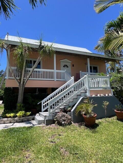 19462 Canal Dr, Sugarloaf, FL 33042 - view of front of house featuring a front yard, stairs, and covered porch
