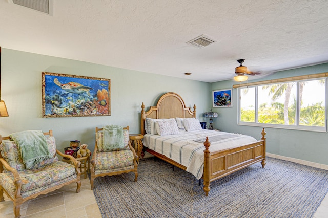 bedroom featuring a textured ceiling, visible vents, and baseboards