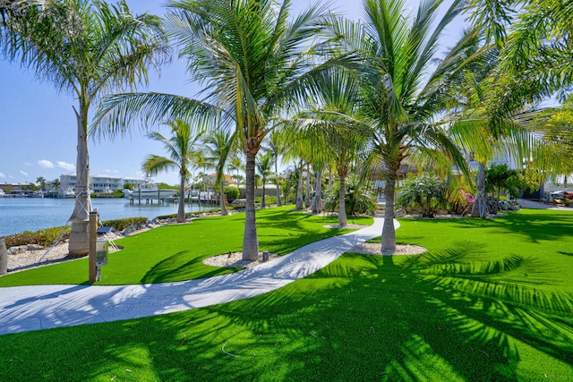 surrounding community with a water view and a yard