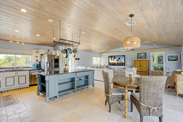 kitchen featuring pendant lighting, appliances with stainless steel finishes, open shelves, and open floor plan