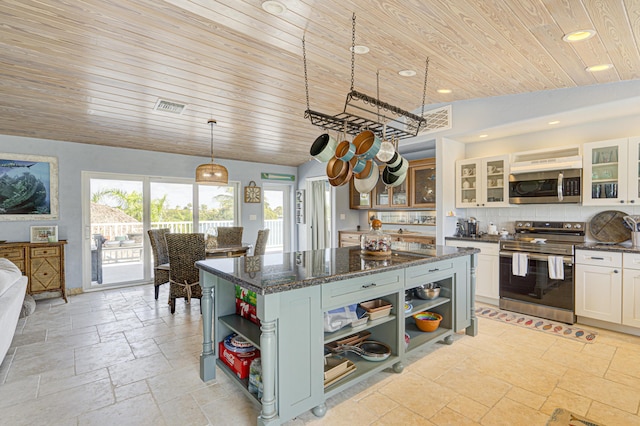 kitchen featuring white cabinetry, hanging light fixtures, appliances with stainless steel finishes, open shelves, and glass insert cabinets