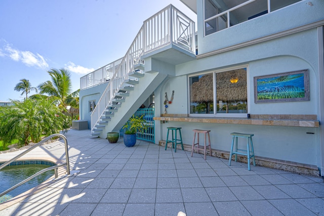 view of patio with a bar and stairs