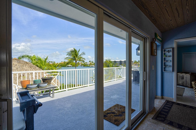 doorway to outside featuring wood ceiling, a water view, and vaulted ceiling