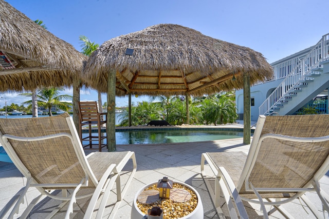 pool featuring a water view, a patio, and stairs