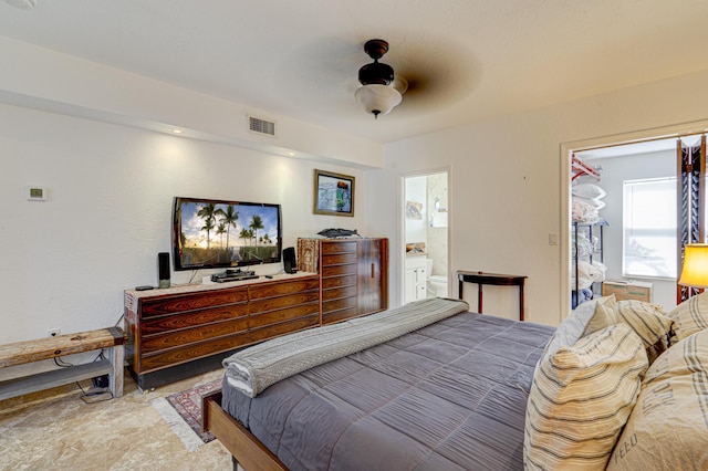 bedroom featuring ensuite bath, visible vents, and ceiling fan