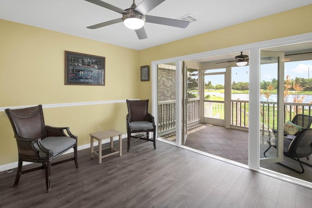 sitting room with ceiling fan and wood-type flooring