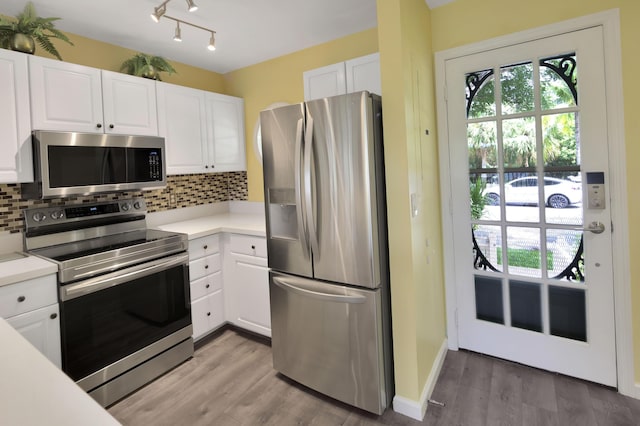 kitchen with stainless steel appliances, white cabinetry, and decorative backsplash