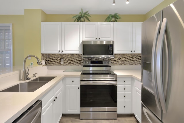 kitchen featuring white cabinetry, appliances with stainless steel finishes, sink, and decorative backsplash