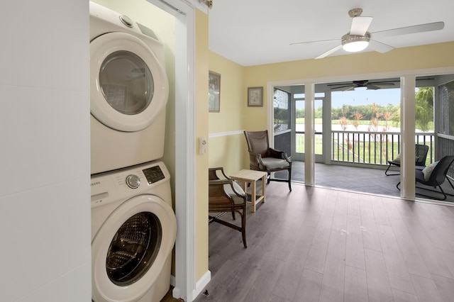 laundry area featuring hardwood / wood-style flooring, ceiling fan, and stacked washer / drying machine