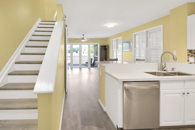 kitchen featuring sink, ceiling fan, white cabinetry, light hardwood / wood-style floors, and stainless steel dishwasher