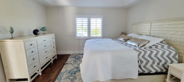 bedroom featuring dark wood finished floors and baseboards