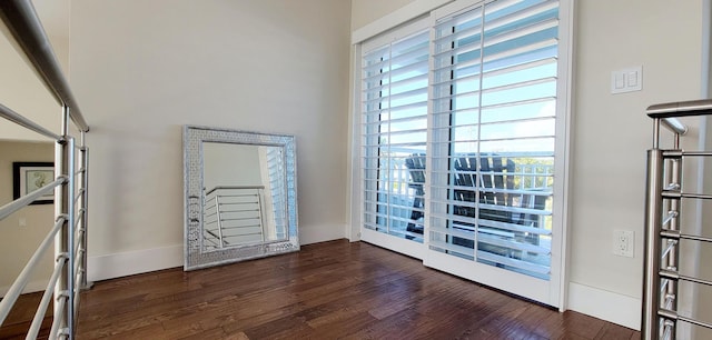 interior space featuring dark wood-style floors, baseboards, and a healthy amount of sunlight