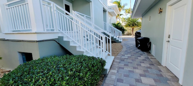 view of property exterior featuring stucco siding and stairway