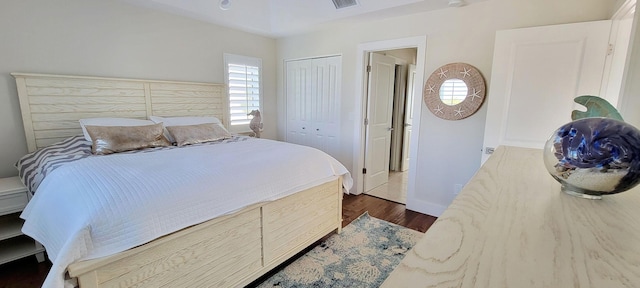 bedroom with visible vents, dark wood-style floors, a closet, and baseboards