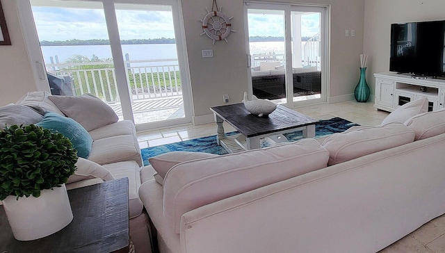 living area with baseboards and a water view