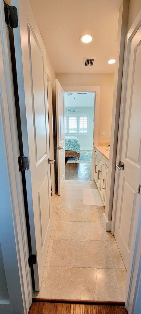 hallway featuring light wood-style flooring, recessed lighting, and visible vents